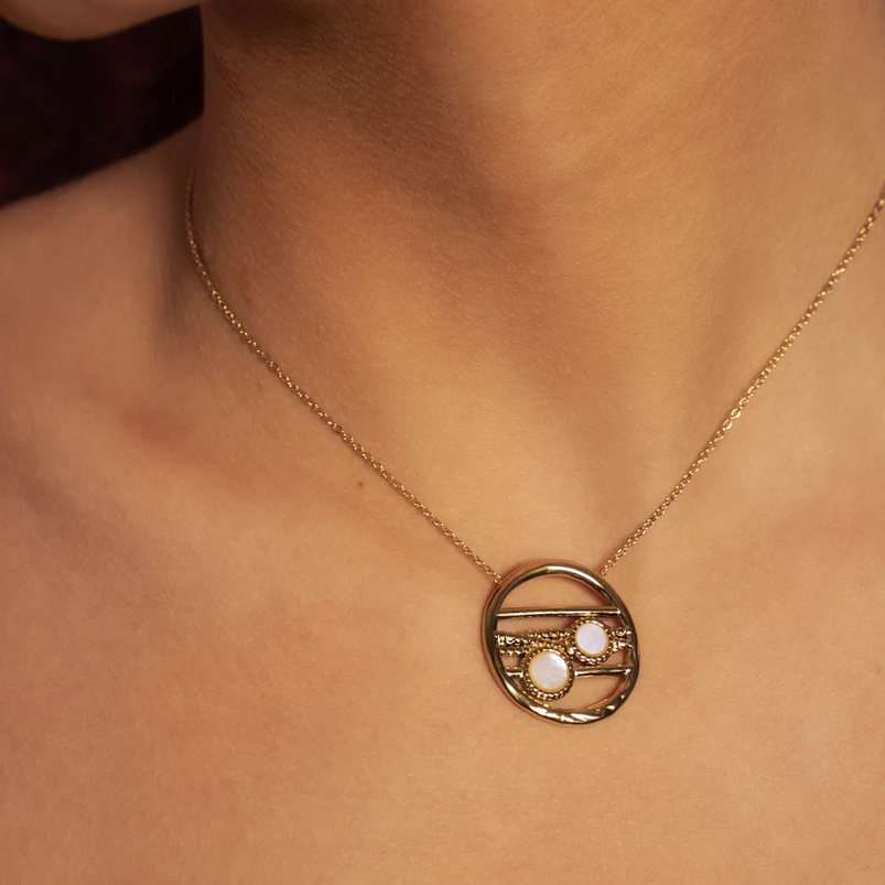 Collier doré avec un pendentif rond ajouré et serti de deux pierres en nacre blanche 38+5 cm