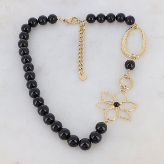 Collier doré composé d'un anneau ovale martelé, d'un anneau rond lisse, d'une fleur et de pierres onyx 42+7 cm