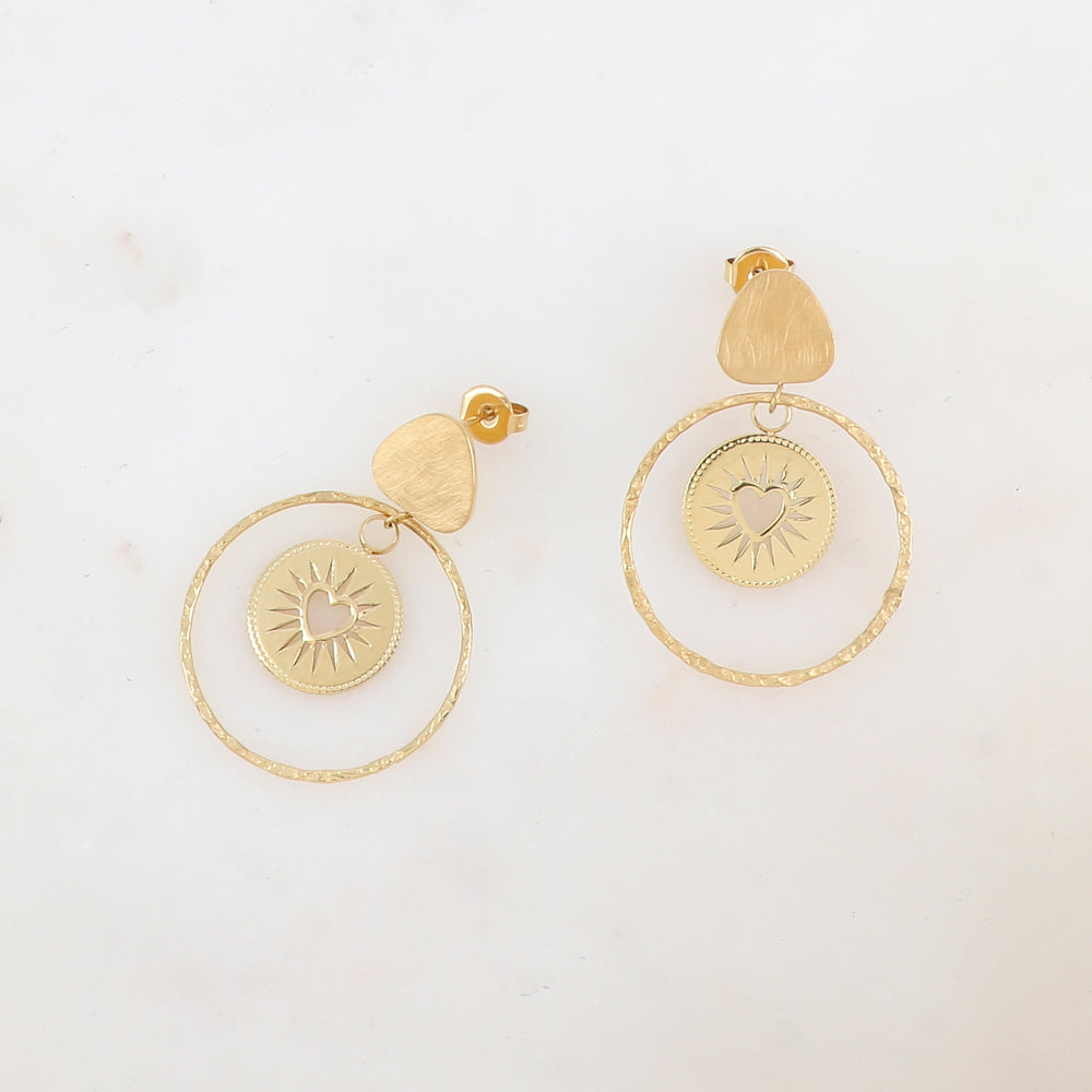 B.O à puce avec triangle arrondi à effet brossé, anneau martelé et pièce ronde ajourée de façon cœur Diamètre anneau : 3,5 cm pièce ronde : 1 cm. Dimension pièce ovale : 2,8 x 3,9 cm.