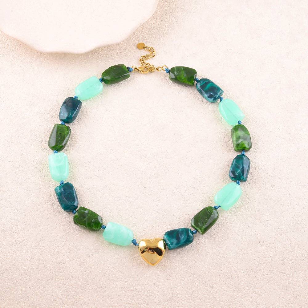 Collier avec une perles forme cœur en acier et des perles en résine couleur vert et turquoise 41+5 cm