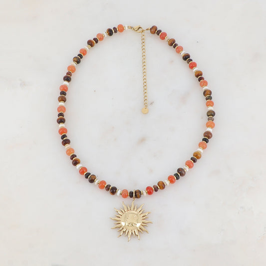 Collier doré composé de perles en pierre noire, blanche, agate orange et oeil de tigre et pendentif forme soleil 39+7 cm