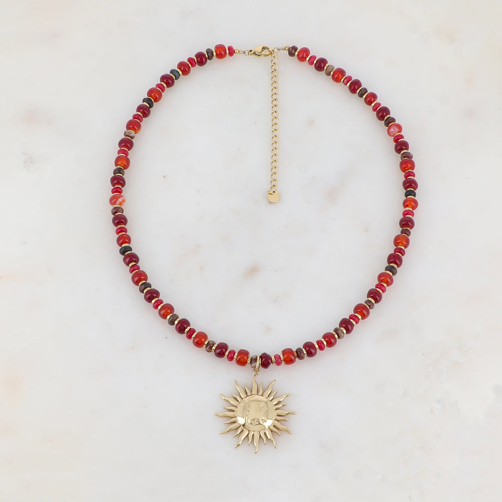 Collier doré composé de perles en pierre rouge et pendentif forme soleil 39+7 cm