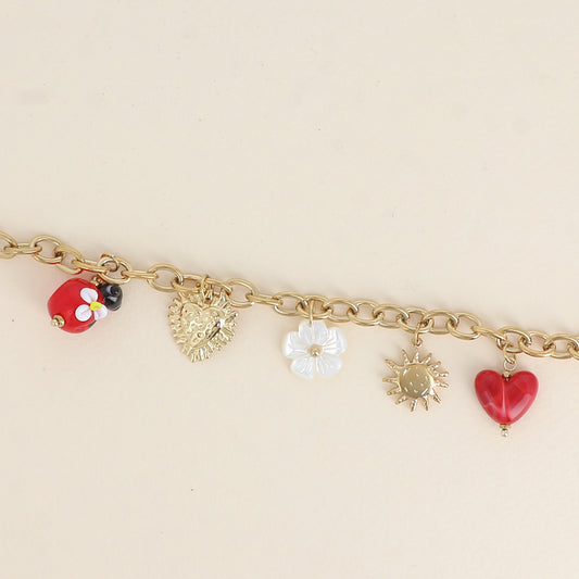 Bracelet - pendentifs (coccinelle en résine, fleur nacrée, cœur, soleil) (17+3 cm)