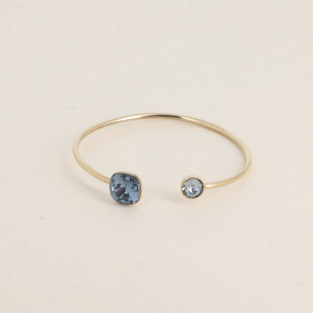 Jonc orné de cristaux de Swarovski® 10 mm et SS29 - Hauteur du jonc: 11 mm - Dimension du cristal 1: 10x10 mm - Diamètre du cristal 2: 7 mm - Denim
