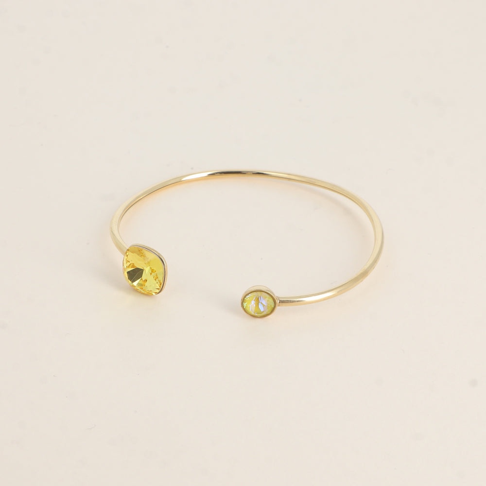 Jonc orné de cristaux de Swarovski® 10 mm et SS29 - Hauteur du jonc: 11 mm - Dimension du cristal 1: 10x10 mm - Diamètre du cristal 2: 7 mm - Light topaz et sunshine delite