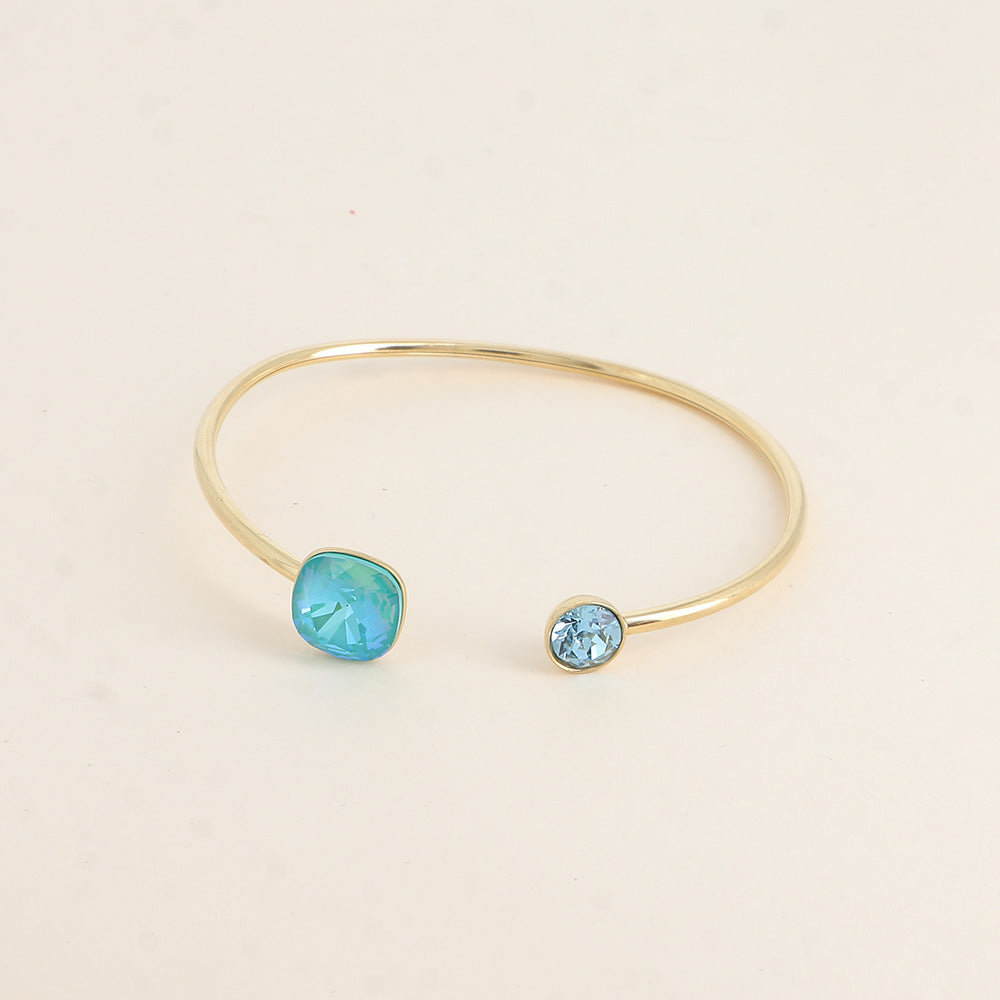 Jonc orné de cristaux de Swarovski® 10 mm et SS29 - Hauteur du jonc: 11 mm - Dimension du cristal 1: 10x10 mm - Diamètre du cristal 2: 7 mm - Laguna delite et aquamarine
