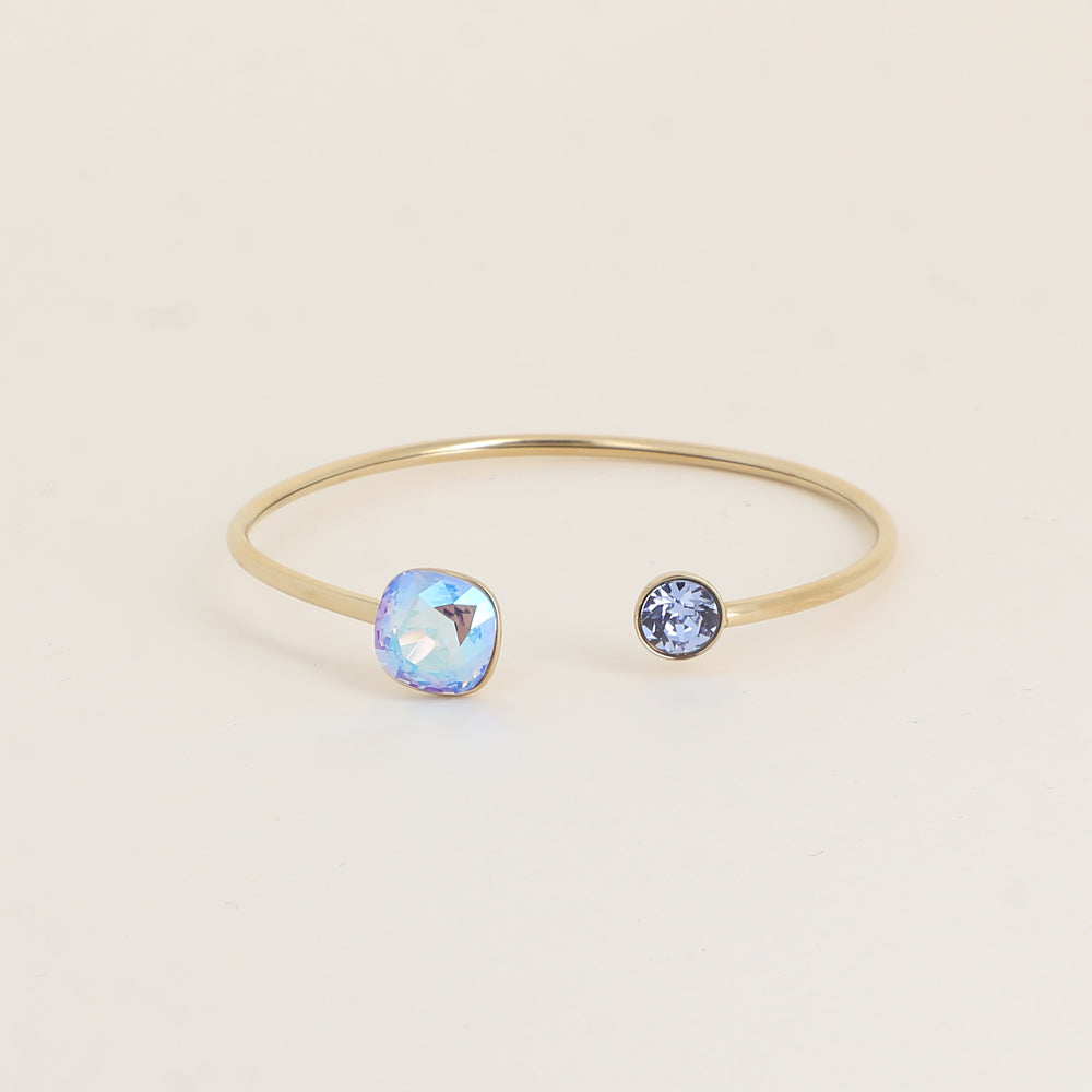 Jonc orné de cristaux de Swarovski® 10 mm et SS29 - Hauteur du jonc: 11 mm - Dimension du cristal 1: 10x10 mm - Diamètre du cristal 2: 7 mm - Light sapphire shimmer et light sapphire