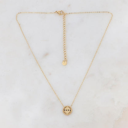 Collier doré avec un pendentif rond ajouré de façon géométrique et orné de 4 strass noirs 38+7 cm