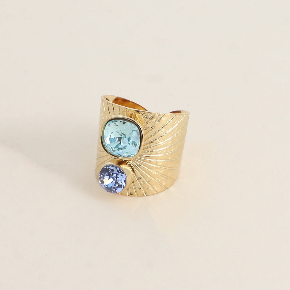 Bague large anneau solairement strié - Ornée de 2 cristaux de Swarovski® - Hauteur de la bague: 20mm - Dimensions des cristaux : 8x8 mm et 6x6 mm - Aquamarine et Light sapphire