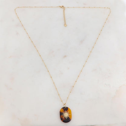 Collier doré composé d'un pendentif en acétate marron léopard orné d'un soleil 65+5 cm