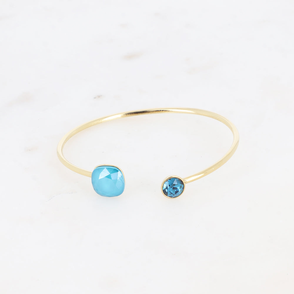 Jonc orné de cristaux de Swarovski® 10 mm et SS29 - Hauteur du jonc: 11 mm - Dimension du cristal 1: 10x10 mm - Diamètre du cristal 2: 7 mm - Azure blue et indicolite