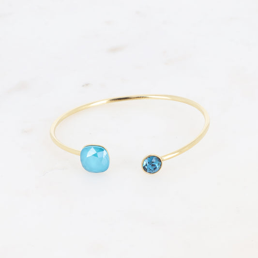 Jonc orné de cristaux de Swarovski® 10 mm et SS29 - Hauteur du jonc: 11 mm - Dimension du cristal 1: 10x10 mm - Diamètre du cristal 2: 7 mm - Azure blue et indicolite