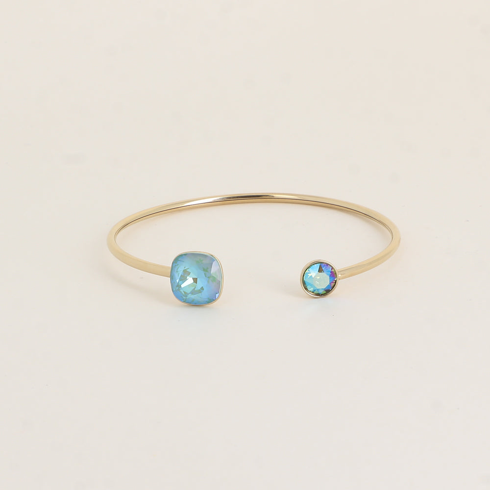 Jonc orné de cristaux de Swarovski® 10 mm et SS29 - Hauteur du jonc: 11 mm - Dimension du cristal 1: 10x10 mm - Diamètre du cristal 2: 7 mm - Silky sage delite et Erinite shimmer