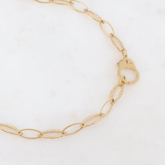 Collier avec pièce en forme de menotte ajourée dorée 40+5 cm