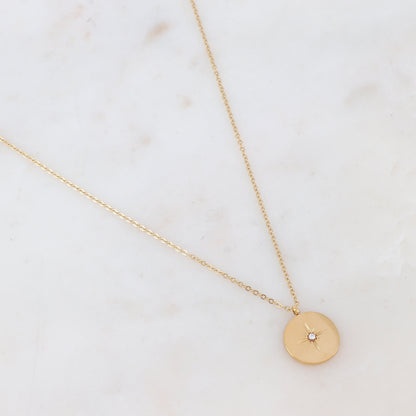 Collier doré composé d'une pièce ronde à motif étoile et ornée d'un strass 40+5 cm
