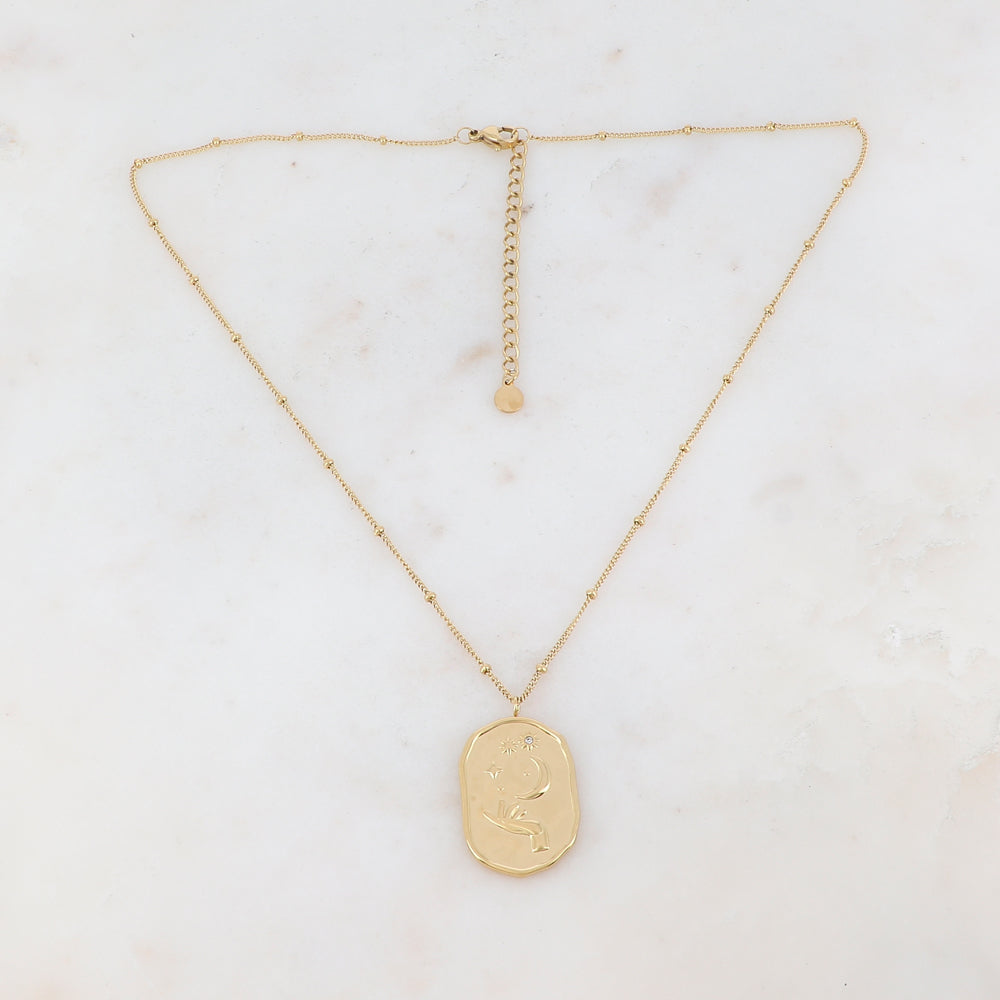 Collier doré composé d'un pendentif en forme géométrique avec différents motifs : main, soleil, lune et étoile, et d'un strass blanc 40+5 cm