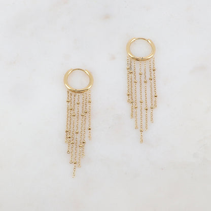 Créoles avec 7 chaînes tombantes et petites boules Diamètre créoles : 1,5 cm. Dimensions chaînes : 4,5 cm, 4 cm, 3,5 cm, 3 cm.