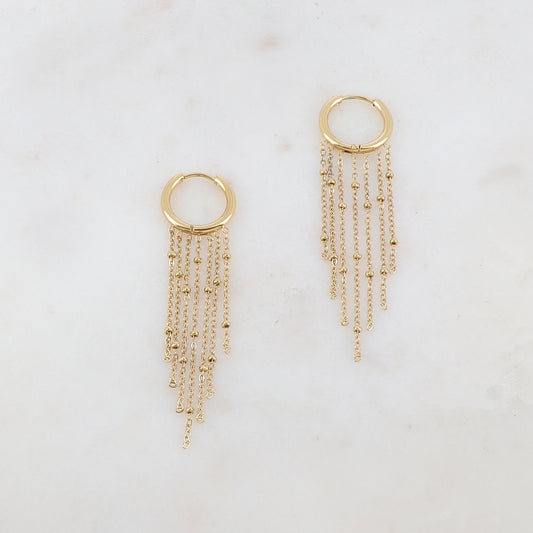 Créoles avec 7 chaînes tombantes et petites boules Diamètre créoles : 1,5 cm. Dimensions chaînes : 4,5 cm, 4 cm, 3,5 cm, 3 cm.