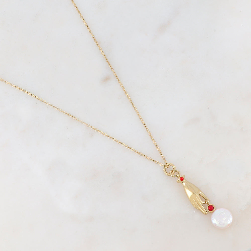 Collier doré composé d'un pendentif main embelli d'un strass rouge, d'une pierre rouge et d'une perle d'eau douce 45+5 cm