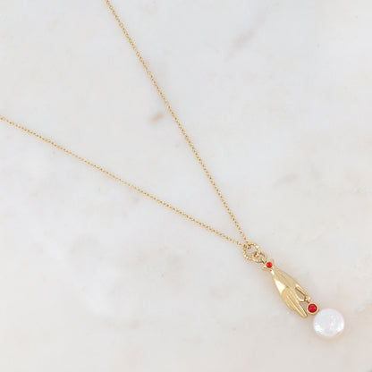 Collier doré composé d'un pendentif main embelli d'un strass rouge, d'une pierre rouge et d'une perle d'eau douce 45+5 cm