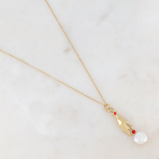Collier doré composé d'un pendentif main embelli d'un strass rouge, d'une pierre rouge et d'une perle d'eau douce 45+5 cm