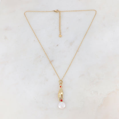 Collier doré composé d'un pendentif main embelli d'un strass rouge, d'une pierre rouge et d'une perle d'eau douce 45+5 cm
