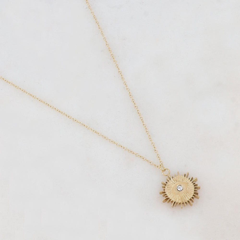 Collier doré composé d'un pendentif ajouré de façon soleil avec œil et strass blanc 41+5 cm