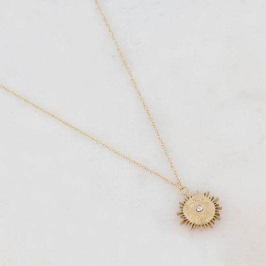 Collier doré composé d'un pendentif ajouré de façon soleil avec œil et strass blanc 41+5 cm