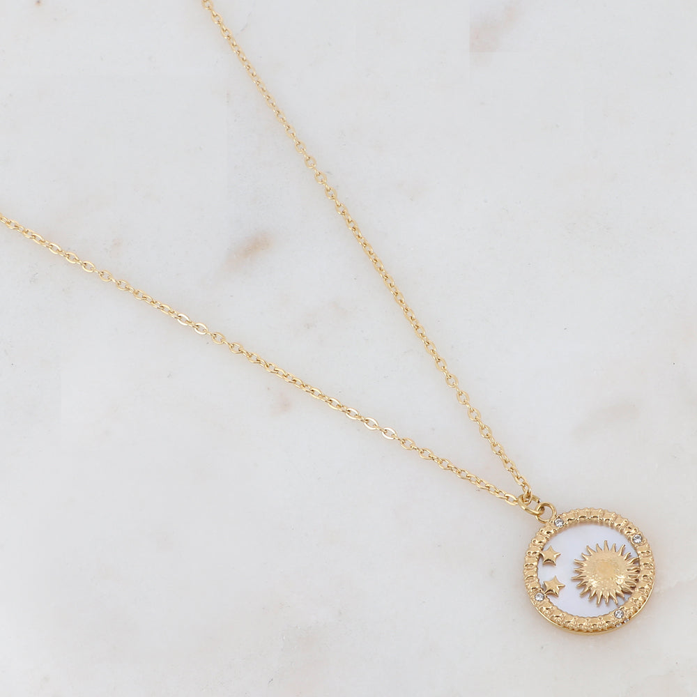 Collier doré composé d'un pendentif rond avec un fond nacré et orné d'étoiles, d'un soleil et de strass blancs 40+5 cm
