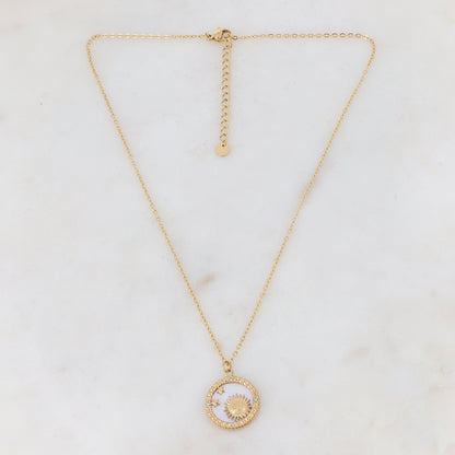 Collier doré composé d'un pendentif rond avec un fond nacré et orné d'étoiles, d'un soleil et de strass blancs 40+5 cm