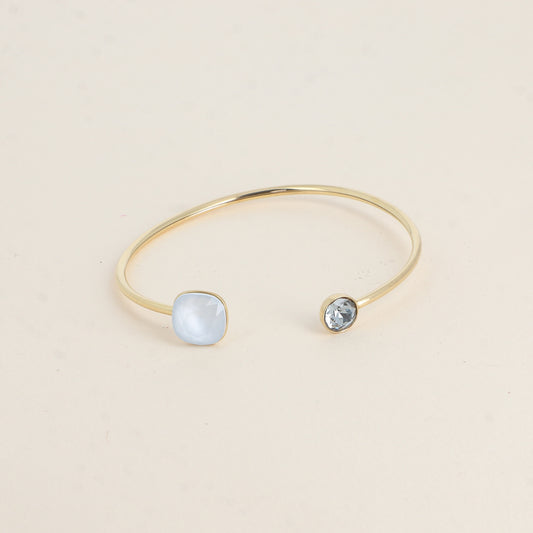 Jonc orné de cristaux de Swarovski® 10 mm et SS29 - Hauteur du jonc: 11 mm - Dimension du cristal 1: 10x10 mm - Diamètre du cristal 2: 7 mm - Powder blue et Indian sapphire