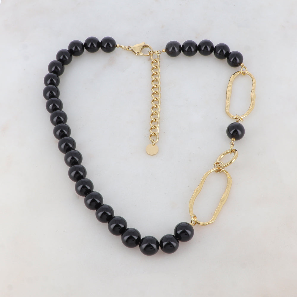 Collier doré composé de 2 anneaux ovales martelés, d'1 anneau rond lisse et de pierres onyx 42+7 cm