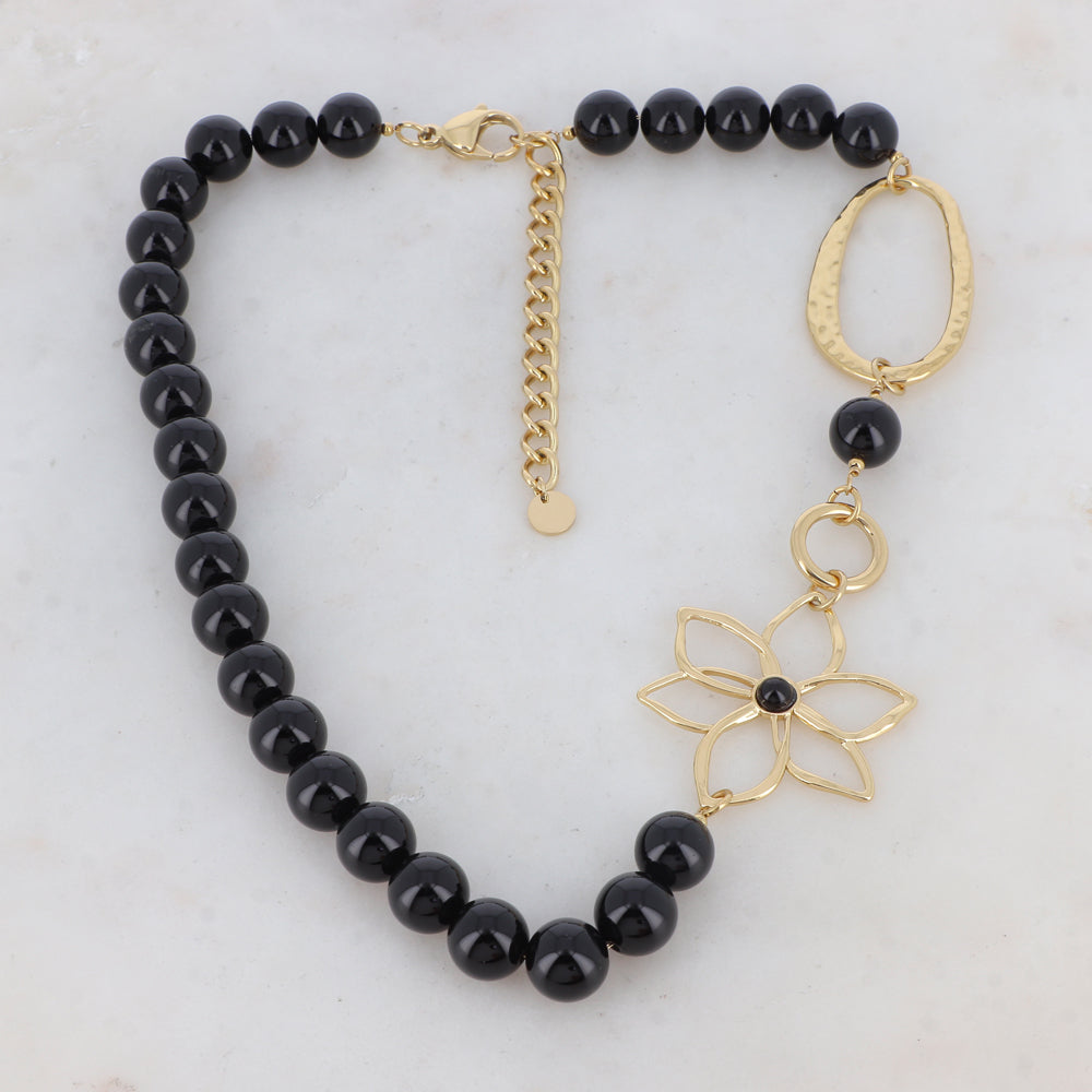 Collier doré composé d'un anneau ovale martelé, d'un anneau rond lisse, d'une fleur et de pierres onyx 42+7 cm