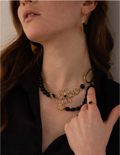 Collier doré composé d'un anneau ovale martelé, d'un anneau rond lisse, d'une fleur et de pierres onyx 42+7 cm