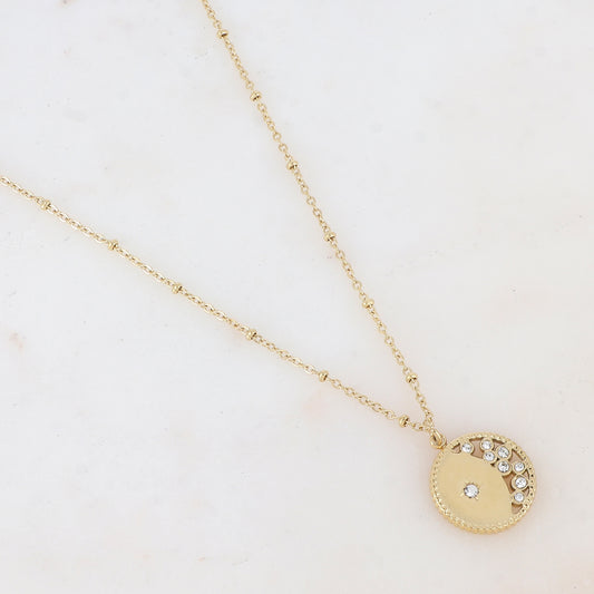 Collier doré composé d'un pendentif rond ajouré embelli de strass blancs 40+5 cm