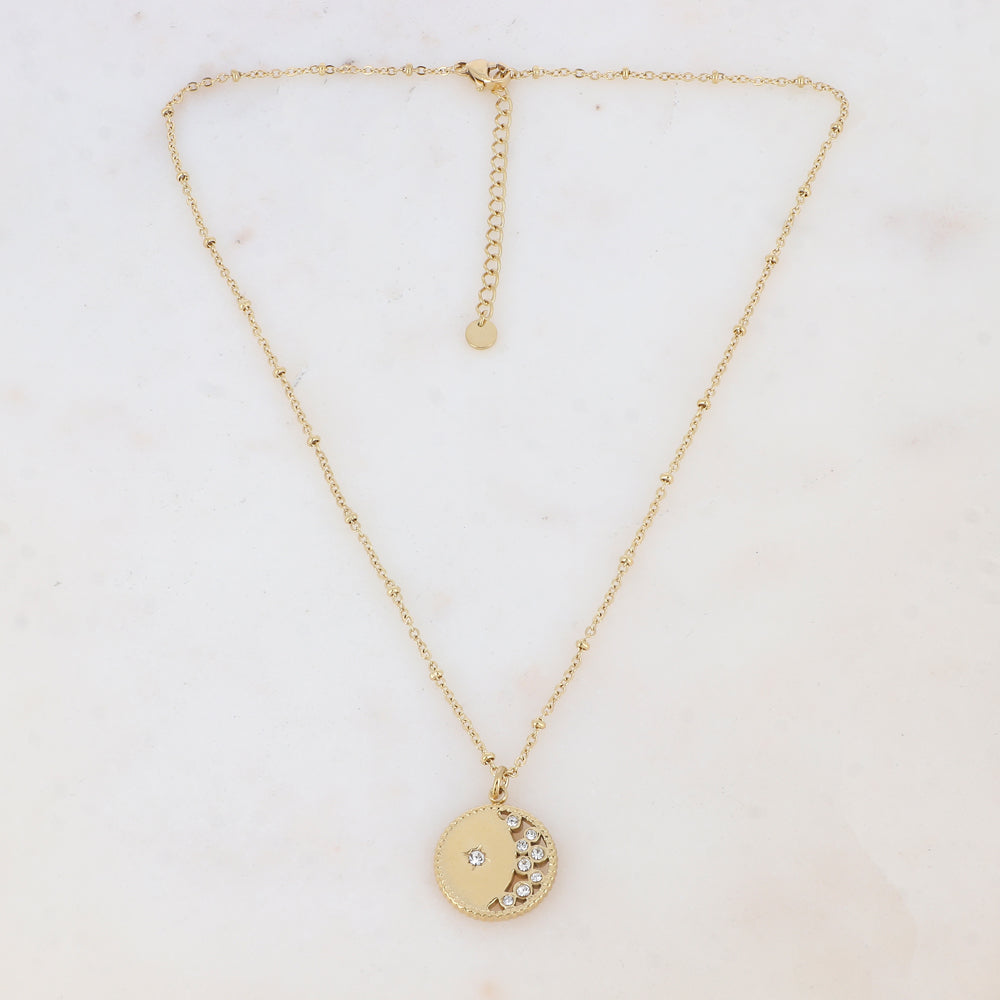 Collier doré composé d'un pendentif rond ajouré embelli de strass blancs 40+5 cm