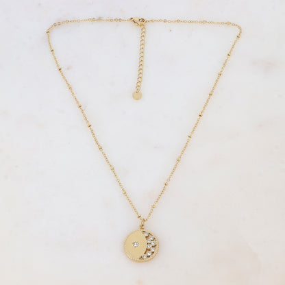 Collier doré composé d'un pendentif rond ajouré embelli de strass blancs 40+5 cm