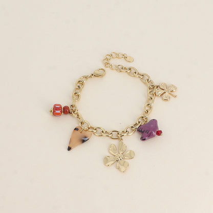Bracelet - perles et oiseau en céramique, trèfle, cœur en résine et fleur (17+3 cm)