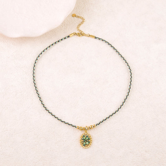 Collier sur cordon avec un anneau ovale texturé et perles en pâtes de verre vertes 39+5 cm