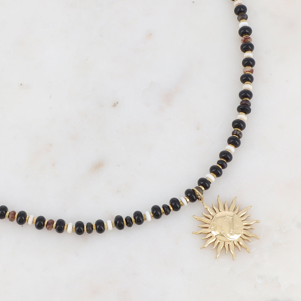 Collier doré composé de perles en pierre naturelle noires et blanches et pendentif forme soleil 39+7 cm