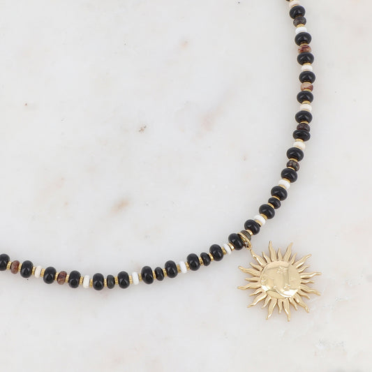 Collier doré composé de perles en pierre naturelle noires et blanches et pendentif forme soleil 39+7 cm