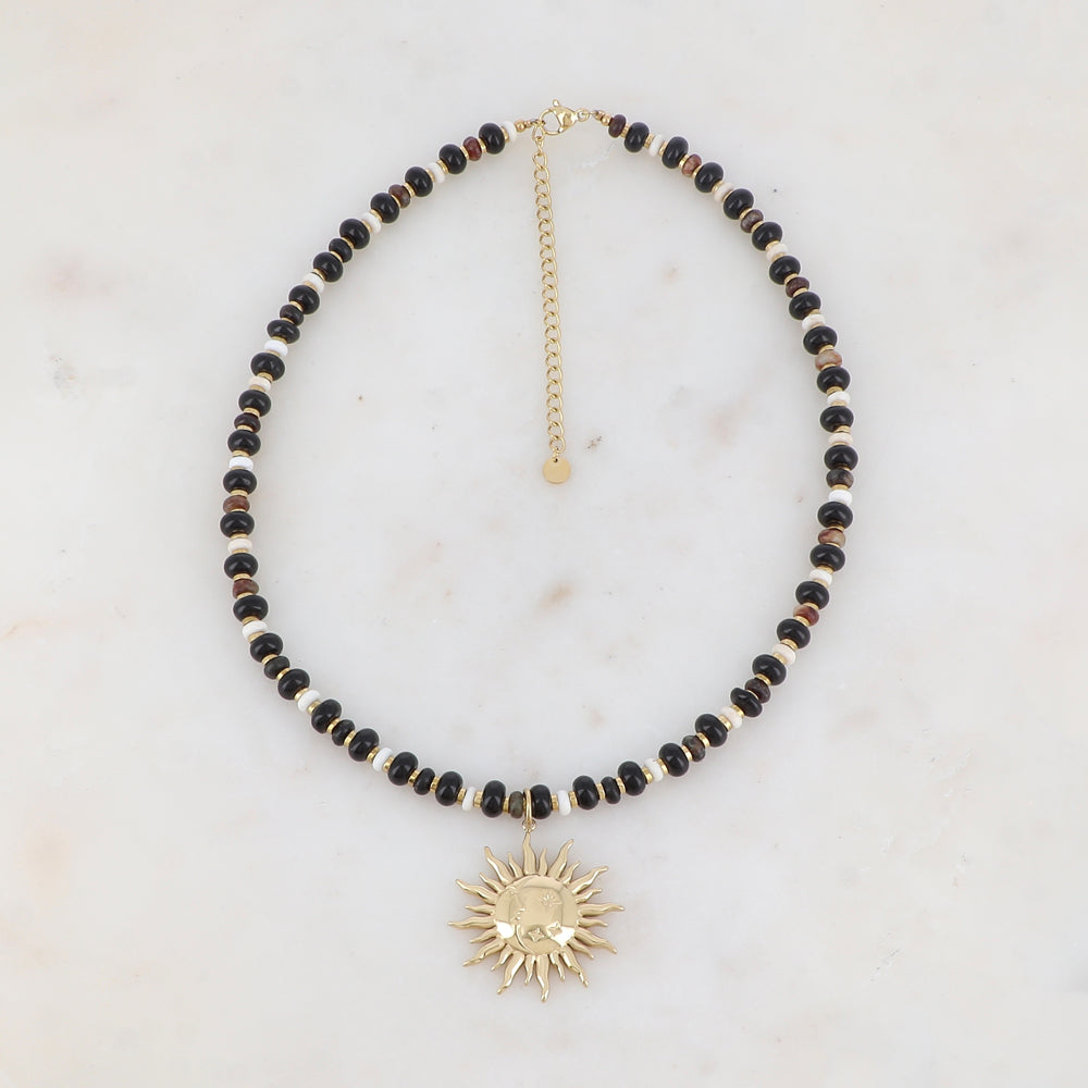 Collier doré composé de perles en pierre naturelle noires et blanches et pendentif forme soleil 39+7 cm