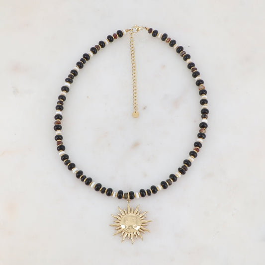 Collier doré composé de perles en pierre naturelle noires et blanches et pendentif forme soleil 39+7 cm