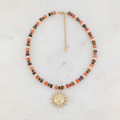 Collier doré composé de perles en pierre noire, blanche, agate orange et oeil de tigre et pendentif forme soleil 39+7 cm