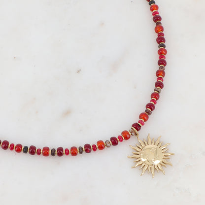 Collier doré composé de perles en pierre rouge et pendentif forme soleil 39+7 cm