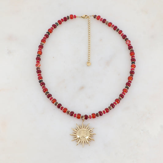 Collier doré composé de perles en pierre rouge et pendentif forme soleil 39+7 cm