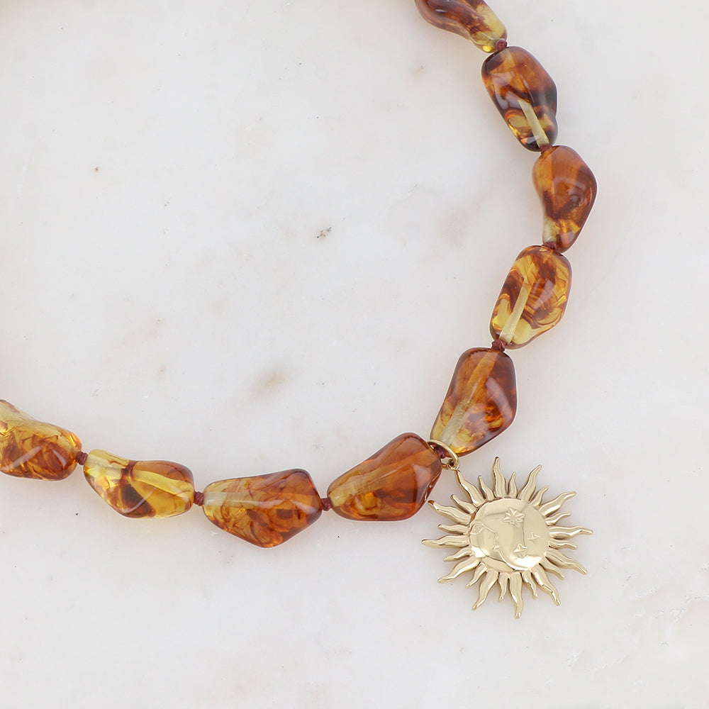 Collier doré avec perles en résine translucide ambre et pendentif forme soleil 39-41 cm