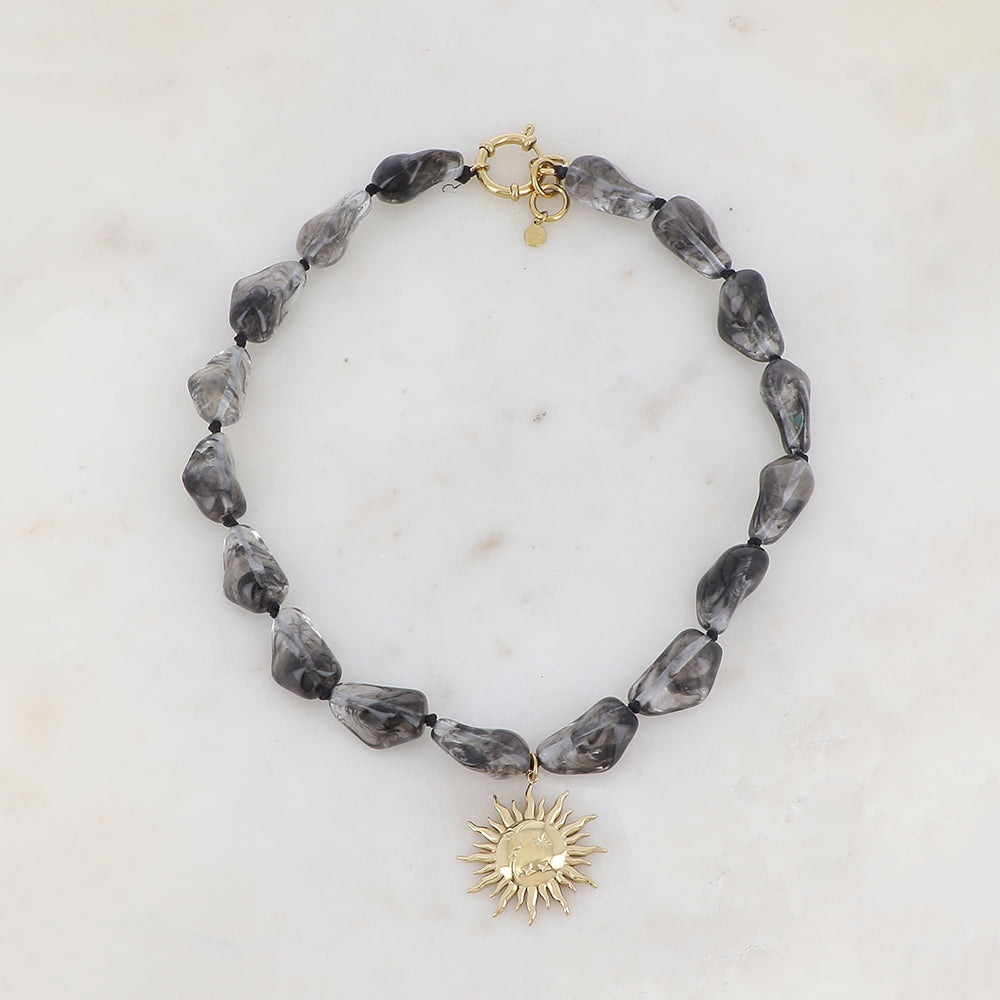 Collier doré avec perles en résine translucide gris et pendentif forme soleil 39-41 cm