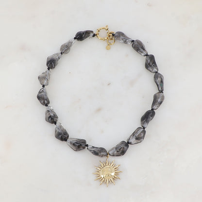 Collier doré avec perles en résine translucide gris et pendentif forme soleil 39-41 cm