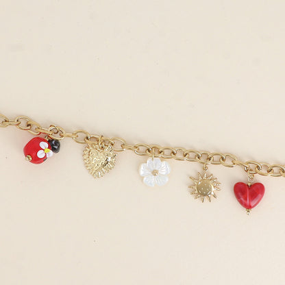 Bracelet - pendentifs (coccinelle en résine, fleur nacrée, cœur, soleil) (17+3 cm)